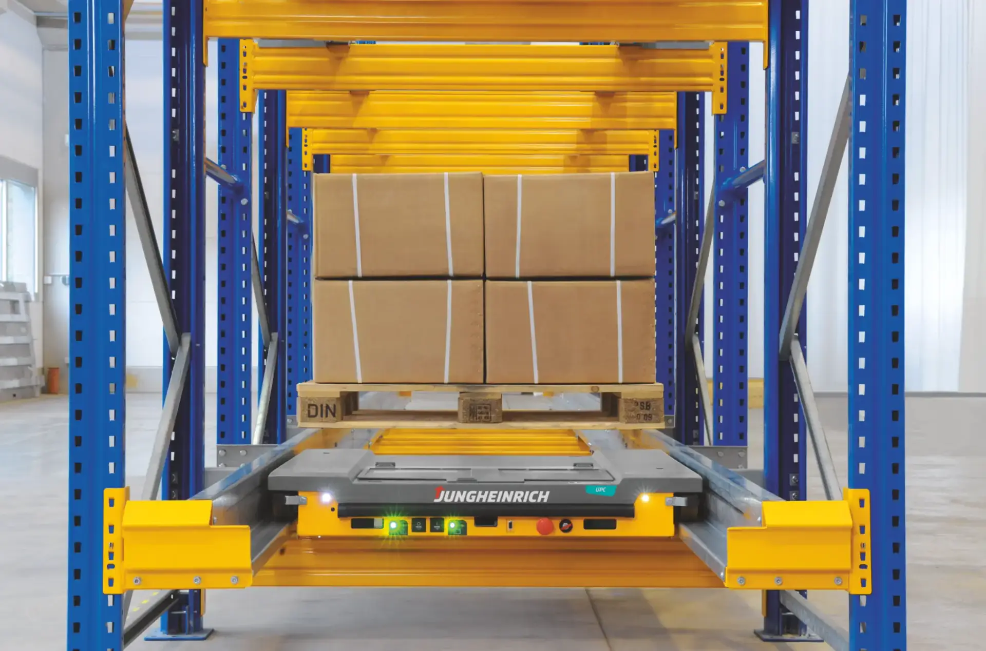 שלושה שאטלים אוטונומיים בצורת משטח שטוח, נעים על מסילות מדפים במערך קומפקטי גבוה