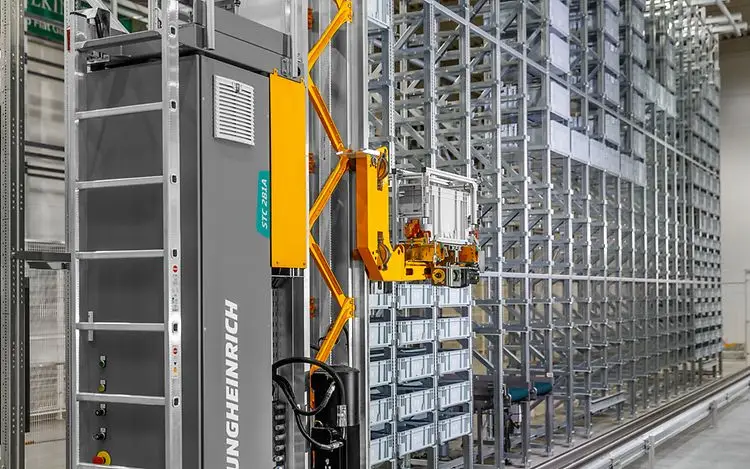 על עגלה מתקדמת של מנוף ערמה Miniload בתוך מסלול אחסון צר, עם זרועות מכניות לאחיזה והרמה של מכולות פלסטיק